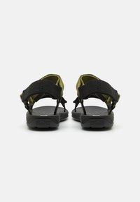 Las sandalias negras y verdes oliva cuentan con correas ajustables, una plantilla texturizada y una suela de goma resistente con un logo estampado.