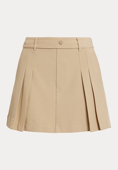 Μπεζ μίνι φούστα με πιέτες, θηλιές για ζώνη και κλείσιμο με κουμπιά μπροστά.