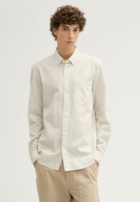 Helles, kariertes Hemd mit subtilen Quadraten, ausgestattet mit einer Brusttasche, langen Ärmeln und einem klassischen Kragen.