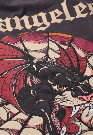 Illustrazione di un pantera nera su un tessuto scuro, con accenti di ragnatela rossa, dettagliati tratti del viso e testo in grassetto che recita "Los Angeles."