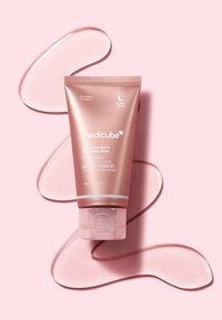 Rurka w kolorze różowego złota maski na noc Medicube Collagen Night Wrapping Mask z przejrzystą żelową konsystencją na różowym tle. Zawiera branding i szczegóły produktu.