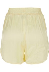 Helle gelbe Shorts mit elastischem Bund, weichem Material und lockerer Passform. Verfügt über einen abgerundeten Saum und keine Taschen. Einfaches, minimalistisches Design.