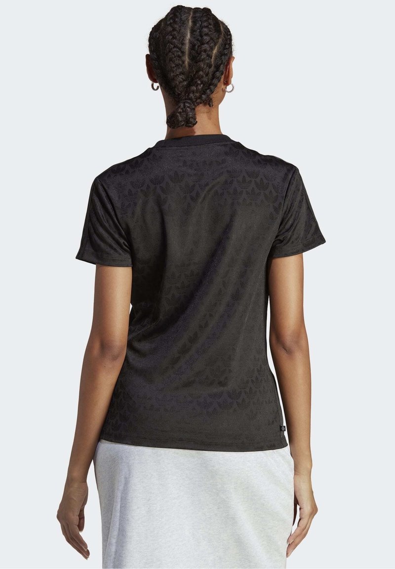 Svart T-shirt med kort ärm som har ett subtilt tonalt mönster, rund halsringning och mjukt tyg, sedd bakifrån.