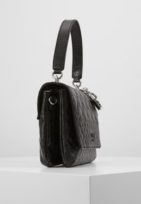 Borsa a tracolla nera trapuntata con una forma strutturata, caratterizzata da una texture liscia, due maniglie, accessori in argento e una coulisse frontale.
