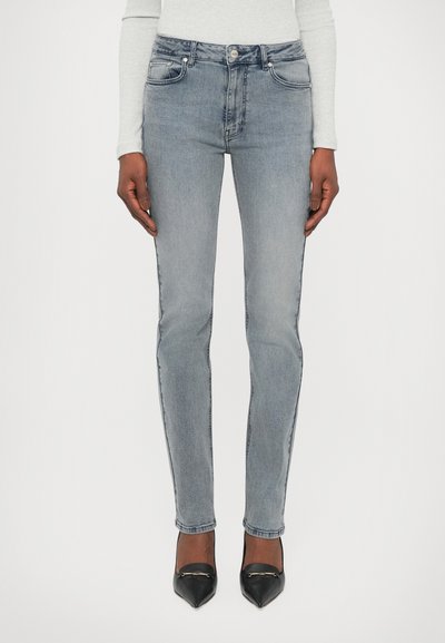 Lysblå jeans i denimstof med slim fit, fem-lomme design, kontraststing, og knaplukning i taljen.