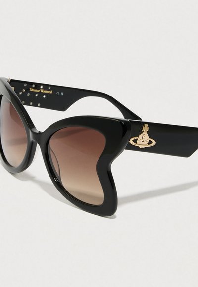 Czarne okulary przeciwsłoneczne w kocim kształcie z gradientowymi brązowymi soczewkami. Posiadają błyszczący szkielet, złoty akcent z logo oraz ozdobne ćwieki na zauszniku.