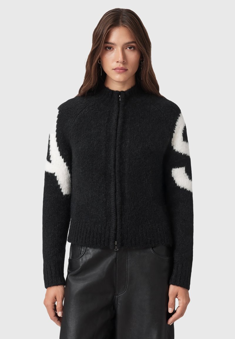 Cardigan zip-up nero con una finitura testurizzata. Presenta un motivo astratto bianco sulle maniche e polsini e orlo a coste. Materiale morbido.
