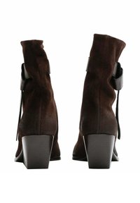 Stivali alla caviglia in suede marrone con un design leggermente sgonfio, tacchi quadrati e dettagli neri sulla parte posteriore e sui lati. Finitura in tessuto testurizzato.