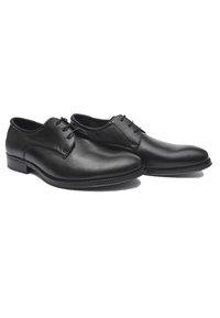Zapatos de vestir de cuero negro con un acabado suave, punta redonda, cordones mínimos y tacón bajo. Presentan un diseño clásico y costuras sutiles.