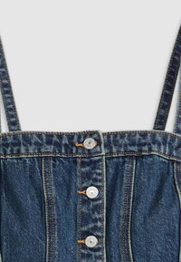 Haut en denim avec des bretelles ajustables, couleur bleue, cinq boutons sur le devant, tissu froncé à la taille et détails de surpiqûres visibles.