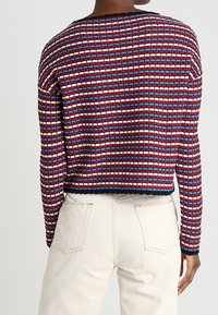 Gebreide trui met een cropped pasvorm, voorzien van een patroon van horizontale rode, witte en blauwe strepen; ronde halslijn en ribbelrand.