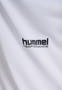 Biała tkanina o fakturze z czarnym logo marki "hummel PERFORMANCE" nadrukowanym na powierzchni.