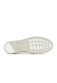 Suola di scarpa bianca con superficie testurizzata, dotata di grip in gomma circolari e ovali, e una punta liscia e arrotondata.