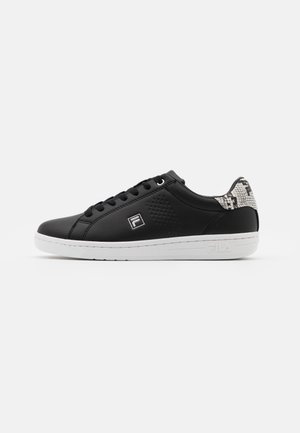 Sort lavtop sneaker med hvid sål, sorte snørebånd, perforeret side, Fila-logo og slangeskinds mønster på hælkanten.