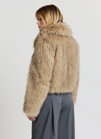 Kunstfelljacke in Hellbeige mit dickem Kragen und kurzem, knapp geschnittenem Design. Verfügt über lange Ärmel und einen leicht lockeren Schnitt.