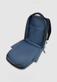 Mochila azul marino con un exterior liso, cierre de cremallera y un interior espacioso que incluye un bolsillo de malla para organización.