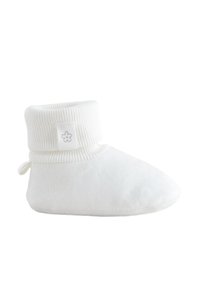 Weicher weißer Baby-Bootie mit geripptem Bündchen und kleinem Blumenlogo auf dem Bündchenlaschen, entworfen für Wärme und Komfort.