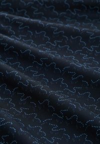 Marine stof met een golvend blauw patroon, met een gladde textuur en subtiele glans. Het ontwerp bestaat uit in elkaar verraste lijnen en stippen.