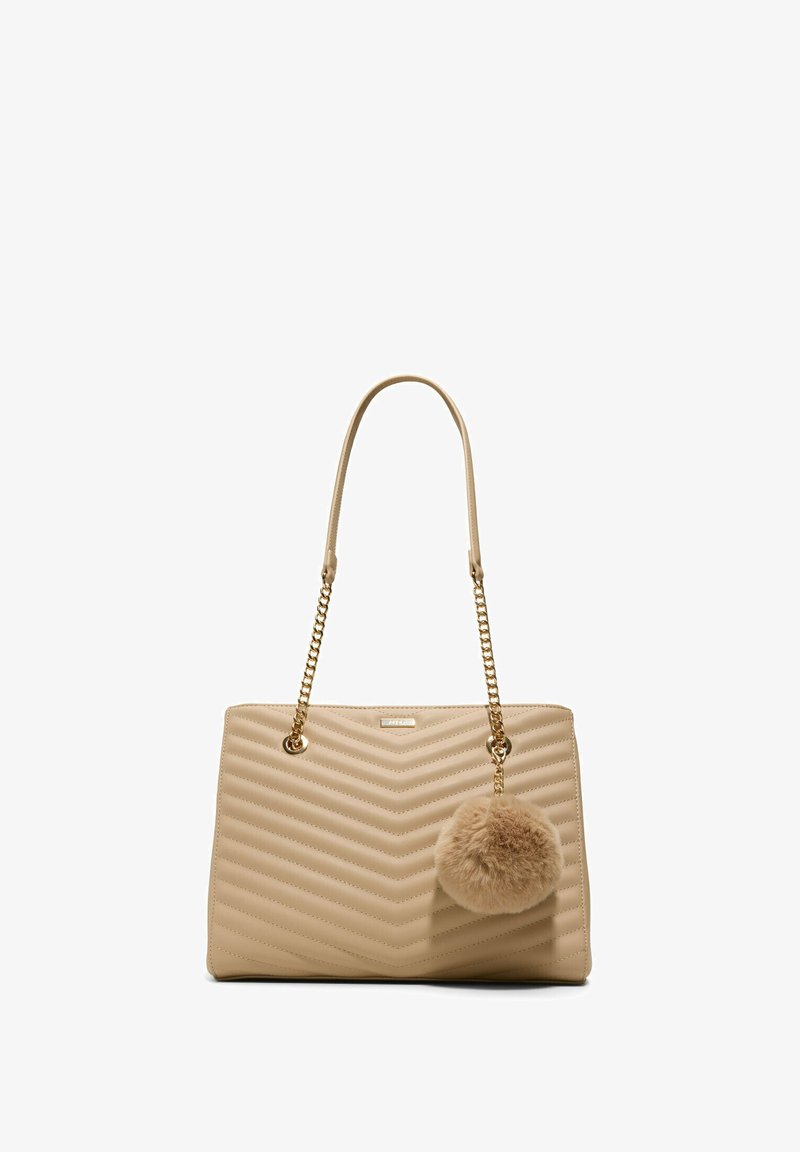 Sac à main beige matelassé avec des sangles chaînées dorées et un grand porte-clés pompon duveteux suspendu à la sangle droite.