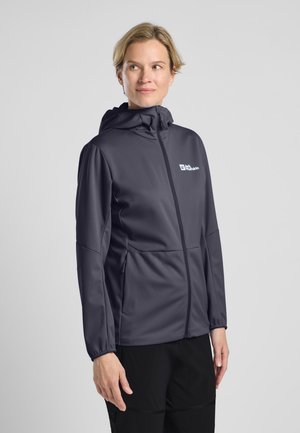 Veste softshell à capuchon de couleur gris foncé, dotée d'une fermeture éclair sur le devant, de poignets élastiques et d'un logo sur la poitrine gauche. Texture lisse.