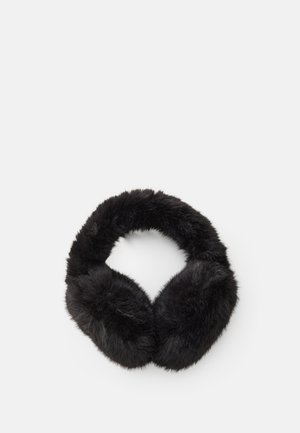 Des cache-oreilles noirs en fausse fourrure disposés en cercle sur un fond blanc uni.