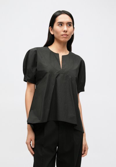 Fekete pamutblúz laza szabással, rövid puffos ujjakkal, V-alakú nyakkivágással és finom textúrával. Párosítva hozzáillő fekete nadrággal.