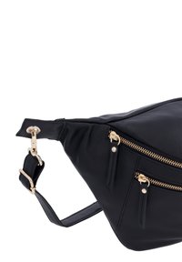 Schwarze Lederhandtasche mit dreieckiger Form, ausgestattet mit goldfarbigen Reißverschlüssen und Beschlägen sowie einem verstellbaren Tragegurt mit Clip. Glatte Textur.