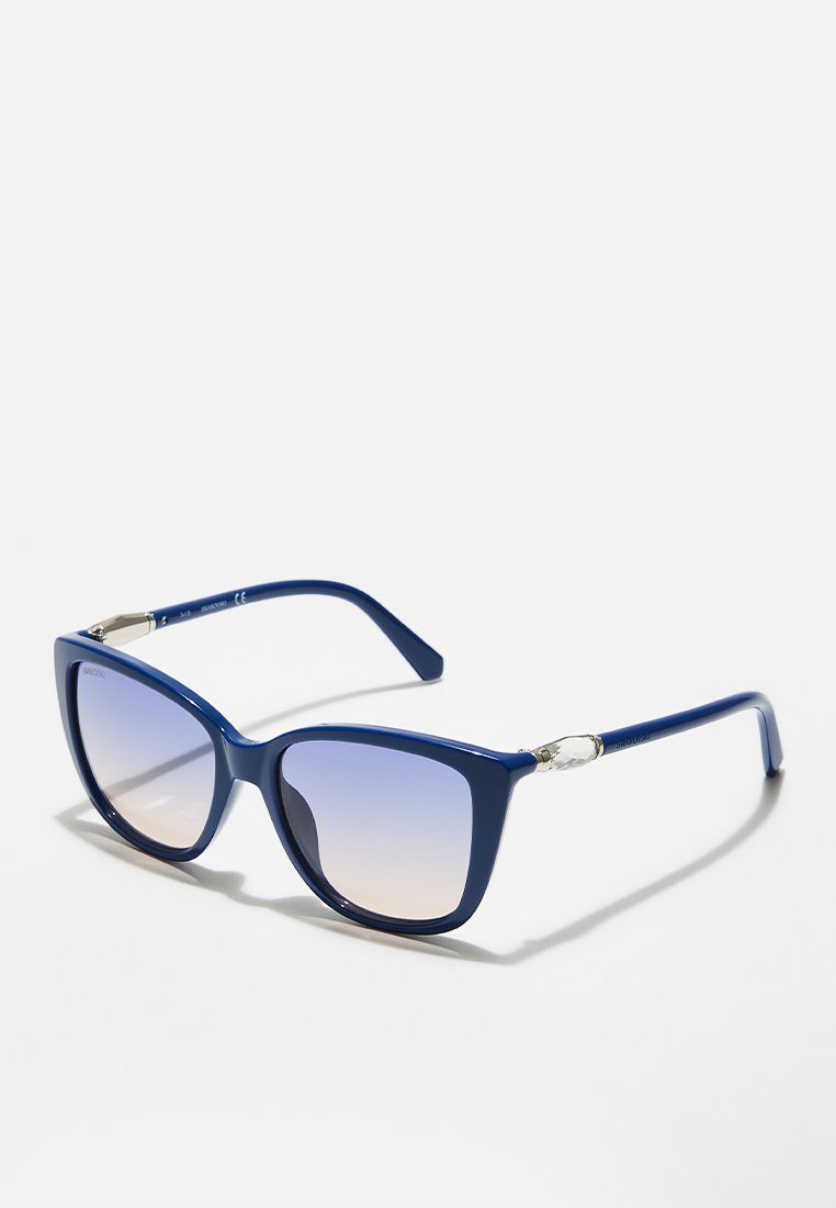 Lunettes de soleil bleues au design œil de chat, avec des verres dégradés, une finition brillante et des accents métalliques sur les charnières.