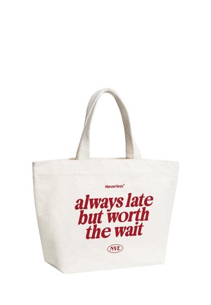 White canvas tote bag with short handles and red text reading "Neverless always late but worth the wait NVL" on the front.