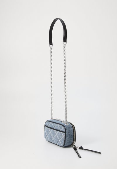 Blue denim crossbody bag with diamond pattern, black leather details, silver chain straps, and zipper closure. Textured, compact design.