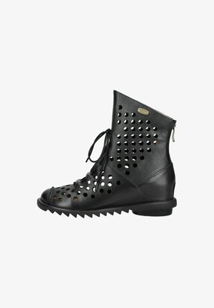Bota de cuero negro hasta el tobillo con perforaciones circulares, cordones delanteros, cremallera en la parte trasera y suela acanalada.