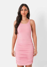Vestito bodycon rosa a coste con arricciature laterali; spalline sottili; design aderente; texture liscia; lunghezza al ginocchio. Senza motivi né accenti.
