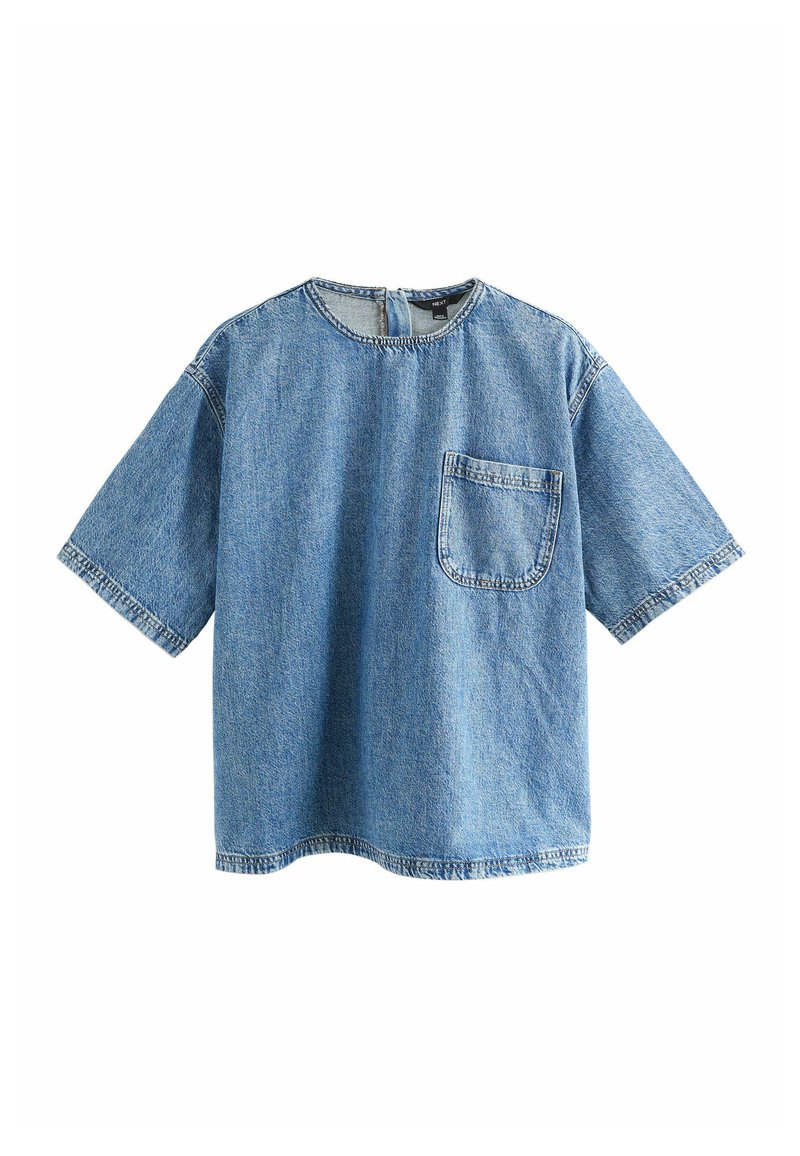 Modrá oversized denimová trička s krátkými rukávy, kulatým výstřihem, kapsou na levé straně a viditelným prošitím podél okrajů.