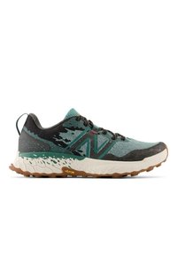 Trailrunschoen met een bovenwerk in teal en zwart, structureel mesh-materiaal, gevoerde crèmekleurige tussenzool en een rubberen buitenzool met noppen voor grip.