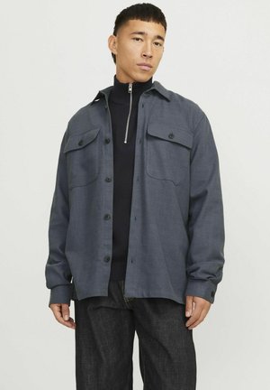 Dark gray shirt jacket with two chest pockets, button closure, and long sleeves. Features fabric texture and a straight cut.
