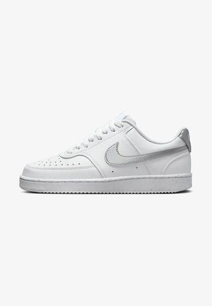 Baskets en cuir blanc avec une pointe arrondie, des perforations décoratives, des accents gris sur le talon et le logo, ainsi qu'une semelle extérieure en caoutchouc texturé.