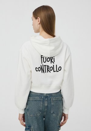Felpa corta bianca con cappuccio e polsini elasticizzati, con la scritta nera "FUORI CONTROLLO" stampata sulla schiena. Tessuto morbido.