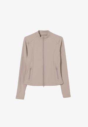 Giacca zip-up di un beige chiaro con un design aderente, maniche lunghe e tasche laterali con zip. Stoffa liscia ed elastica con colletto alto.