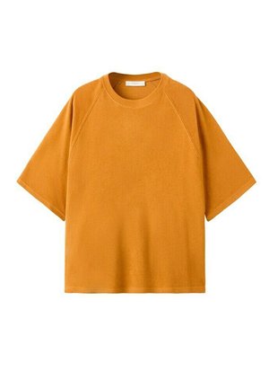 Camiseta de manga corta de color amarillo mostaza con cuello redondo y mangas raglán, exhibida extendida sobre un fondo blanco.