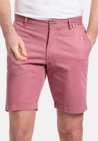 Shorts en coton rose avec une coupe décontractée, dotés de poches avant, d'une fermeture à bouton et d'un petit accent drapeau italien sur la taille.