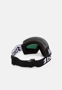 Occhiali da sci neri con lente verde, telaio testurizzato e fascia nera regolabile con logo bianco. Fori di ventilazione visibili sulla parte superiore.