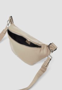 Beige neplederen heuptasje met een ritsopening, verstelbare riem en zilverkleurige hardware. De binnenkant is zwart met een labeldetail.