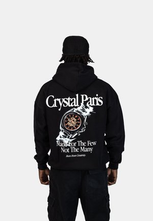 Felpa nera con cappuccio che presenta una grafica di un orologio sul retro, con il testo bianco "Crystal Paris", "Made For The Few Not The Many" e "Time Never Stops".