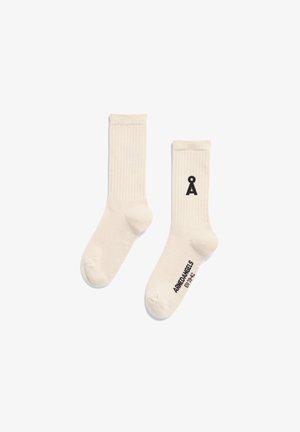 Cream-colored cotton socks with ribbed texture. Features a black graphic logo and brand text on the side. Standard sock shape.