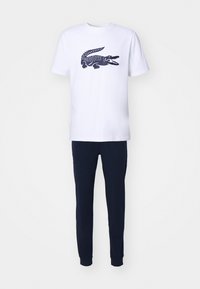 Tricou alb din bumbac cu un grafic de crocodil bleumarin pe față. Asortat cu pantaloni jogger din fleece bleumarin, cu manșete și talie elastice.