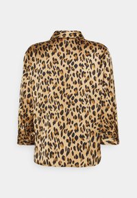 Blouse en satin à imprimé léopard, présentant un motif doré et noir, des manches longues et un col classique.