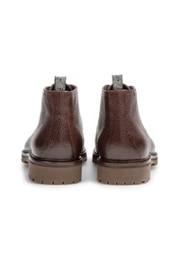 Botas de tobillo de cuero marrón con textura granulada, suela de goma resistente y una lengüeta en la parte posterior, con un diseño de acento en marrón y gris.
