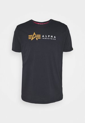 Juodas medvilninis marškinėlis su auksiniu ir baltu "ALPHA INDUSTRIES" logotipu ir geometriniu akcentu priekyje. Trumpomis rankovėmis ir apvalia iškirpte.
