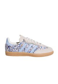 Sneaker mit Blumenmuster, beigem Wildleder-Obermaterial, hellblauen Akzenten und drei blauen Streifen. Gummisohle mit strukturiertem Grip.