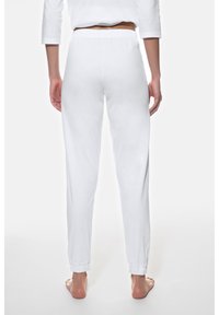 Pantalones deportivos blancos y ligeros con cintura elástica y puños en los tobillos. Textura suave, diseño sencillo sin patrones ni detalles destacados.